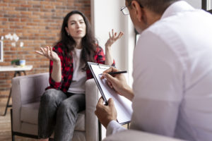 Psychologist taking notes while in session with patient.