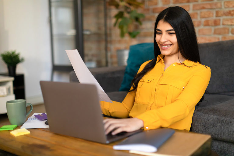 Student enrolled in an online counseling bachelor's degree program doing coursework on laptop