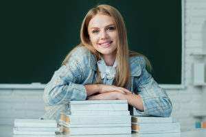 Psychology doctorate student with books in college classroom