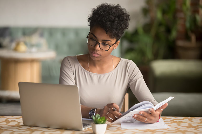 Woman studying for an online master's degree in school counseling at laptop.