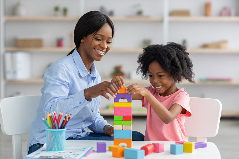 Child psychologist working with a young girl in a school setting.