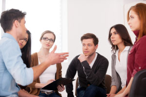 Counselor leading a group therapy meeting.