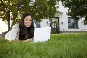 Master's in Counseling student studying on laptop outdoors