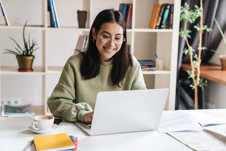 Woman working on laptop to complete an online graduate certificate in health psychology