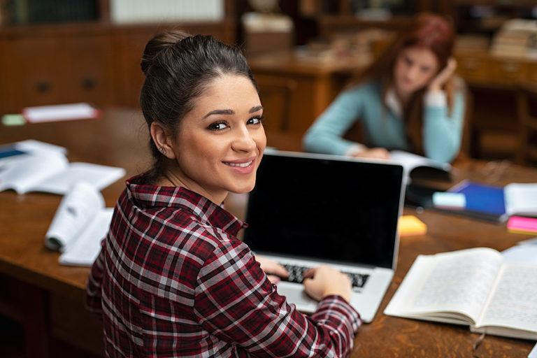 Health Psychology student studying for a master's degree on her laptop in a university library