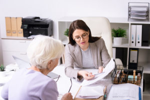 Social worker helping elderly client in an office