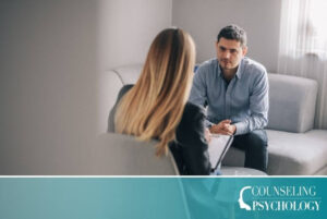A mental health counselor sits with a patient in an office.
