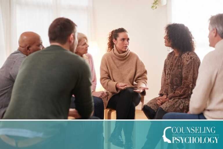 A mental health counselor specializing in addiction counseling meets for a group therapy session in her office with patients seated in chairs in a circle.